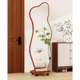 Modern full-length wavy mirror with a natural wood frame and rounded base, placed in a stylish living room corner.
