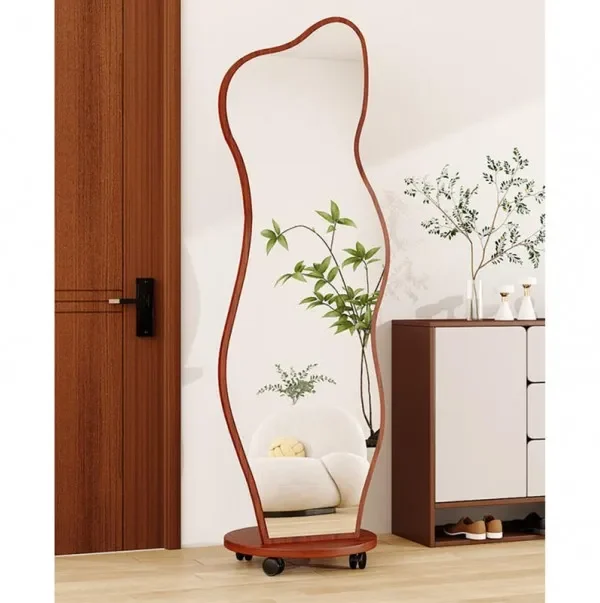 Modern full-length wavy mirror with a natural wood frame and rounded base, placed in a stylish living room corner.